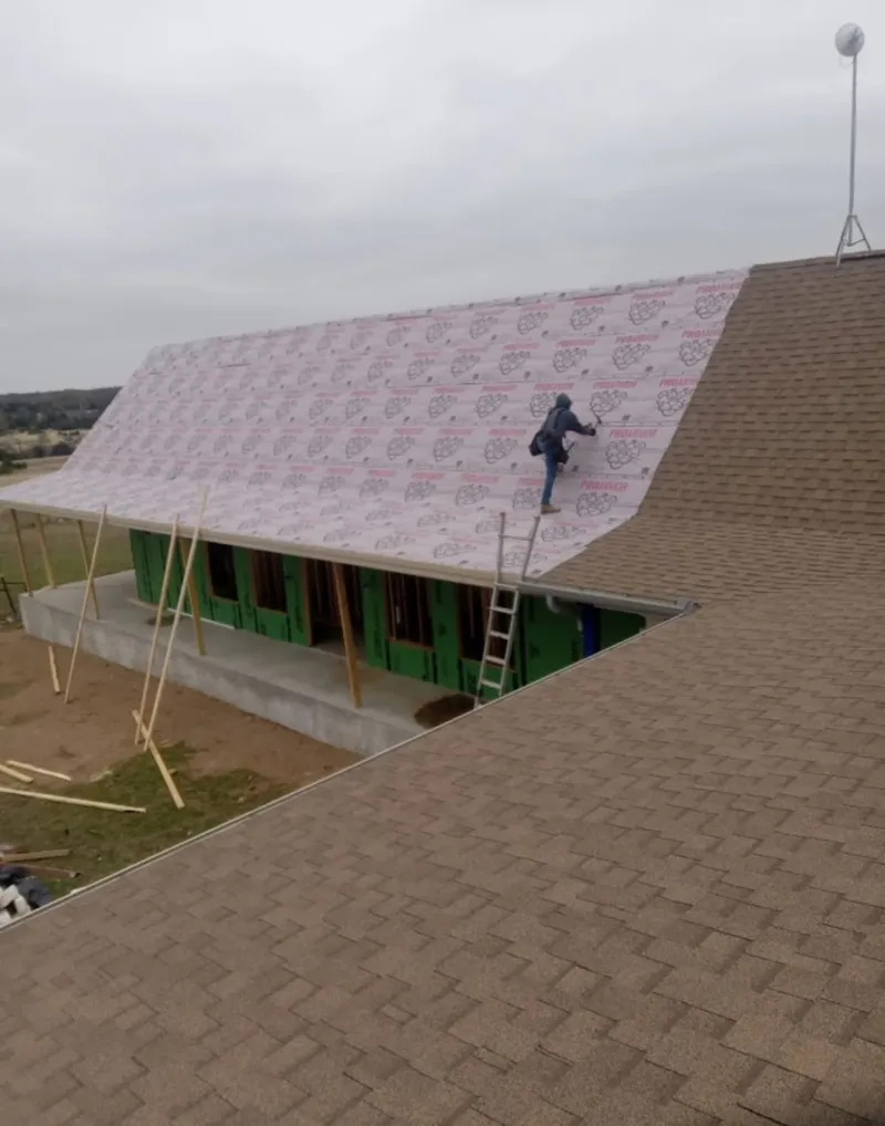 Worker preparing underlayment for a metal roof installation in Fort Campbell North